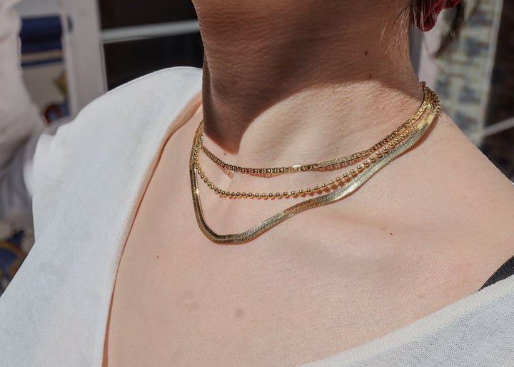 Un collier en or précieux, pure, fin et subtile, une superpositions de carreaux dorés