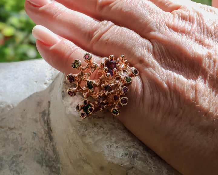 Une bague e pierres précieuses de toutes les couleurs et en or rose, dans un style d'anémone marine